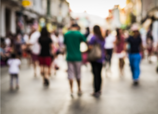 a group of people walking down a busy sidewalk 